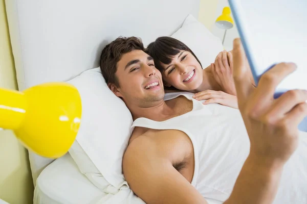 Ζευγάρι χρησιμοποιώντας ψηφιακή δισκίο σε κρεβάτι — Φωτογραφία Αρχείου