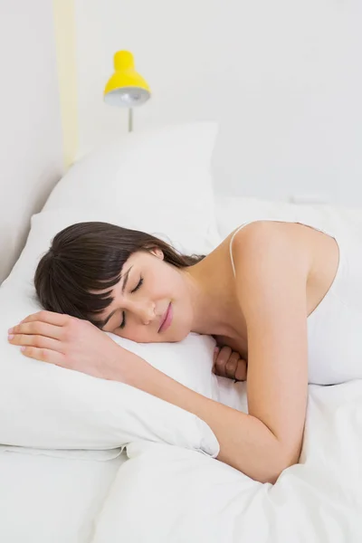 Mujer joven relajándose en la cama — Foto de Stock