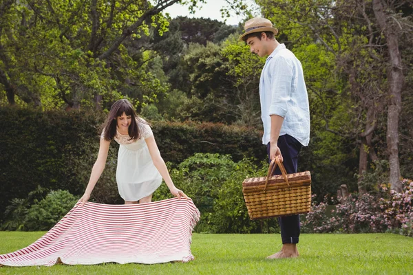 Woman putting picnic blanket in garden — Stock Photo, Image