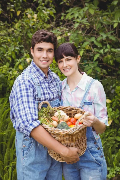 Jovem casal segurando uma cesta — Fotografia de Stock