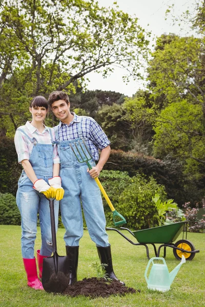 Молодая пара держит лопату и лопату — стоковое фото
