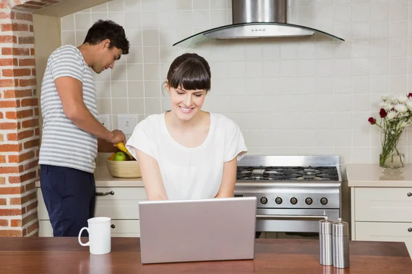 Mulher usando laptop na cozinha — Fotografia de Stock