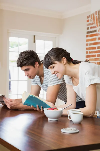 Joven pareja leyendo libro mientras desayuna —  Fotos de Stock