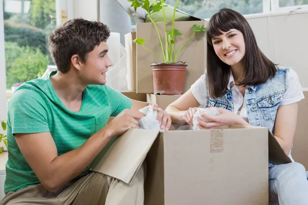 Pareja joven desempacando cajas de cartón en su nueva casa — Foto de Stock