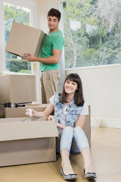 Jonge vrouw uitpakken kartonnen doosjes — Stockfoto