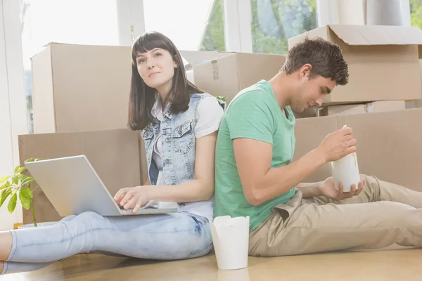 Casal jovem comer macarrão e usando laptop — Fotografia de Stock