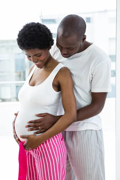 W ciąży para obejmując w sypialni — Zdjęcie stockowe