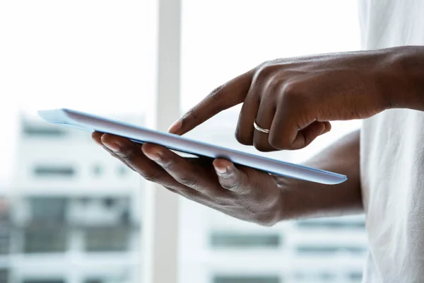 Uomo utilizzando tablet digitale vicino alla finestra — Foto Stock