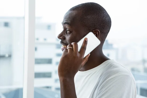 Ο άνθρωπος μιλάει στο κινητό τηλέφωνο κοντά σε παράθυρο — Φωτογραφία Αρχείου