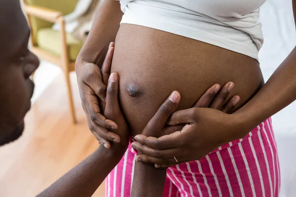 Aanraken van de buik van zwangere vrouw man — Stockfoto