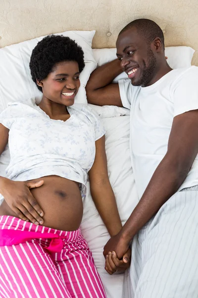 Casal grávida relaxante na cama — Fotografia de Stock