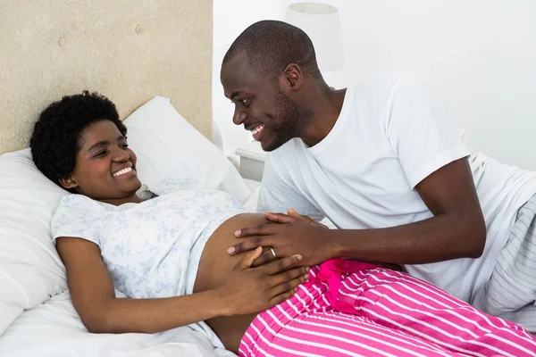 Mann berührt Schwangeren beim Entspannen im Bett — Stockfoto