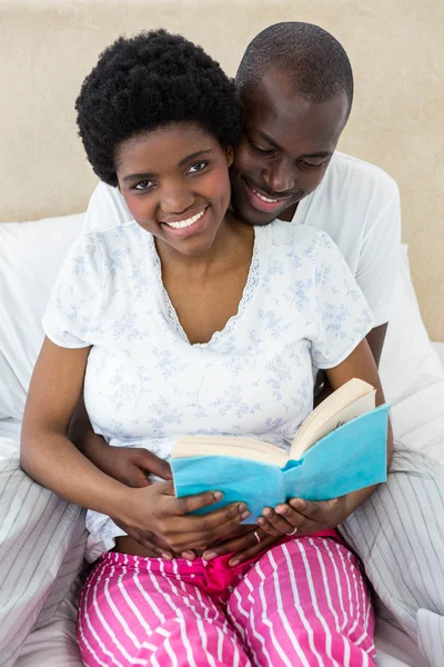 Casal grávida lendo um livro — Fotografia de Stock