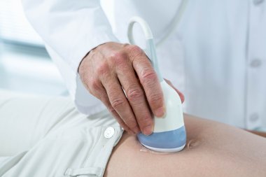 Pregnant woman undergoing ultrasound test clipart