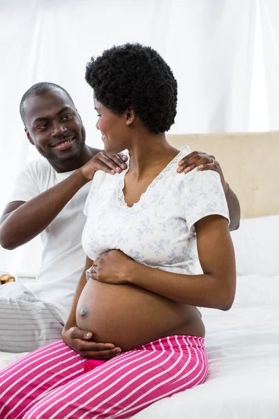 Man masseren zwangere dames schouder op bed — Stockfoto