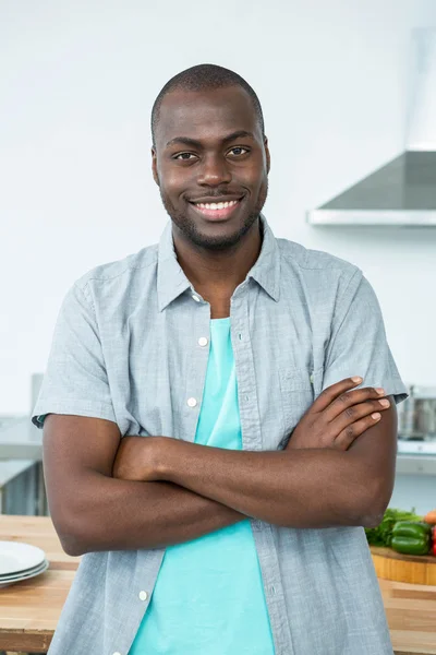 Man standing with arms crossed in kitchen — Stock Photo, Image