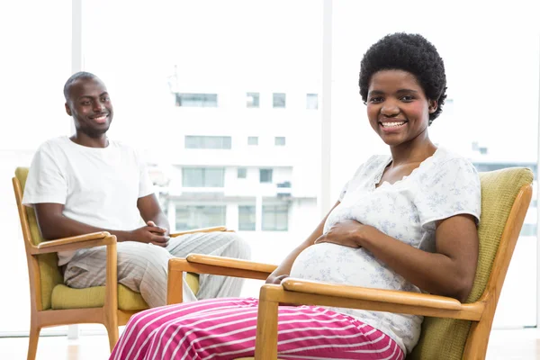 Pregnant couple sitting on chair — Stock Photo, Image