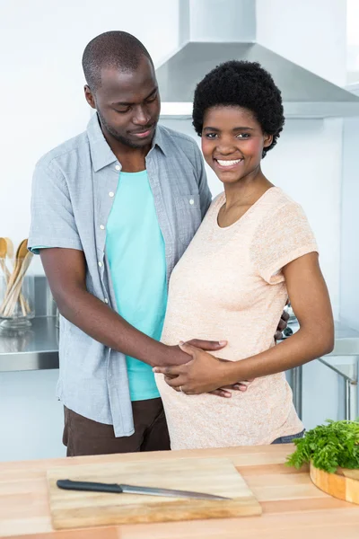 Man touching pregnant womans stomach in kitchen — Stock Photo, Image