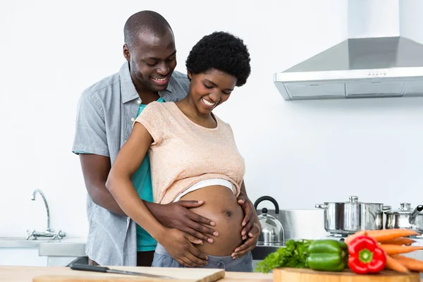 Casal grávida abraçando na cozinha — Fotografia de Stock