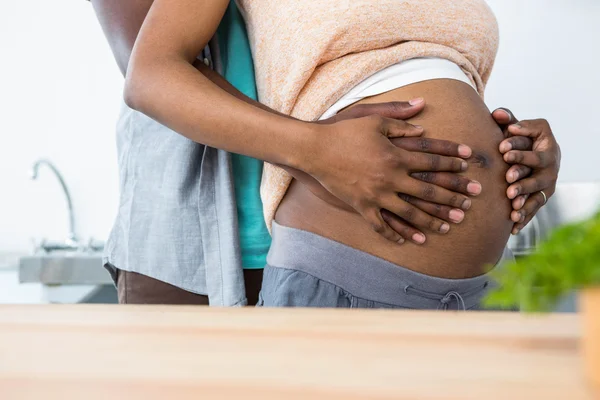 W ciąży para obejmując w kuchni — Zdjęcie stockowe