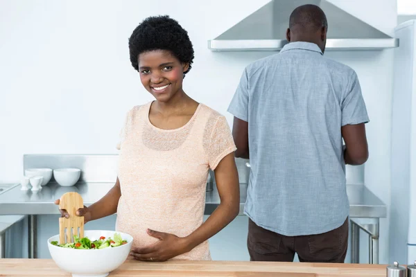 Mulher grávida preparando salada na cozinha — Fotografia de Stock