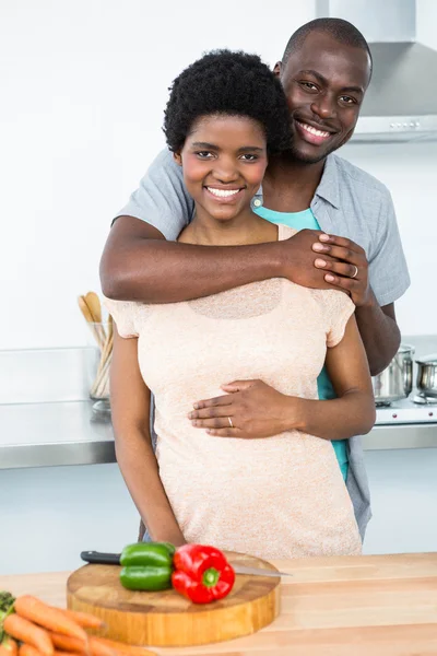 Έγκυος ζευγάρι αγκαλιάζει στην κουζίνα — Φωτογραφία Αρχείου
