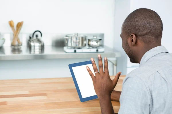 Человек с помощью цифрового планшета на кухне — стоковое фото
