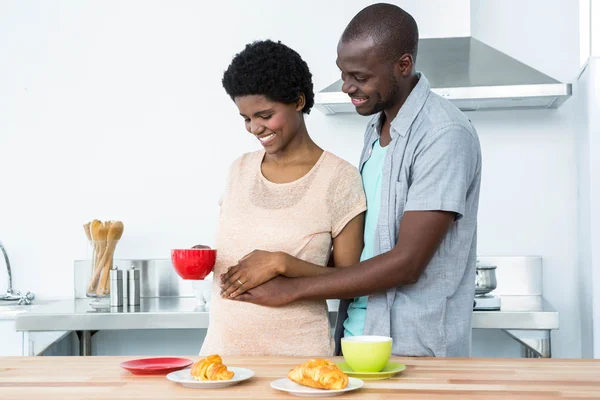 Casal grávida tomando café da manhã na cozinha — Fotografia de Stock