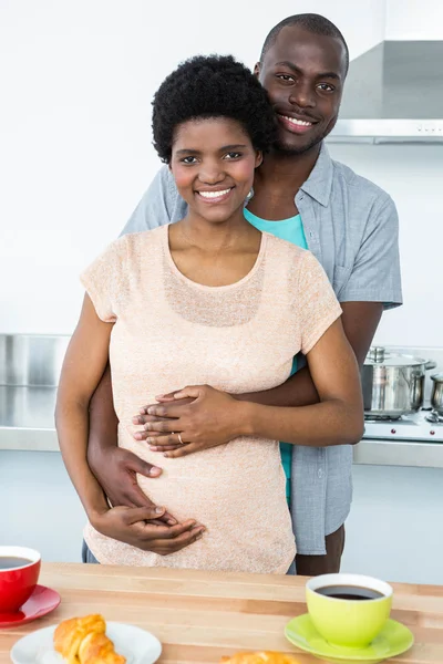 Pregnant couple embracing while having breakfast — Stock Photo, Image