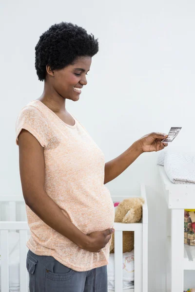 Těhotná žena drží ultrazvukem — Stock fotografie
