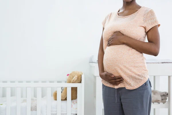 Έγκυος γυναίκα να στέκεται κοντά σε λίκνο — Φωτογραφία Αρχείου