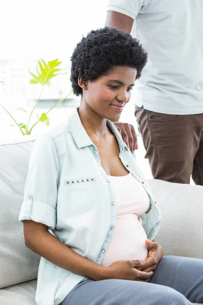 Pregnant woman sitting with hand on stomach — Stock Photo, Image