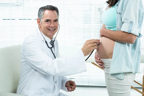 Médico examinando uma mulher grávida — Fotografia de Stock