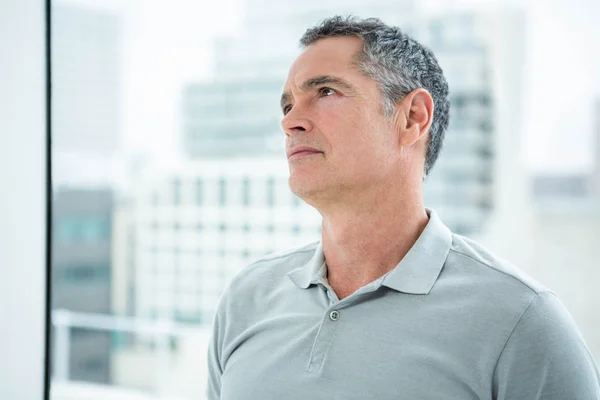 Tensed hombre de pie contra la ventana — Foto de Stock