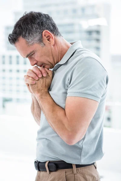 Tensed hombre de pie contra la ventana — Foto de Stock