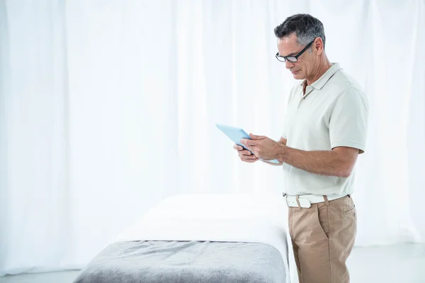 Physiotherapist using digital tablet — Stock Photo, Image