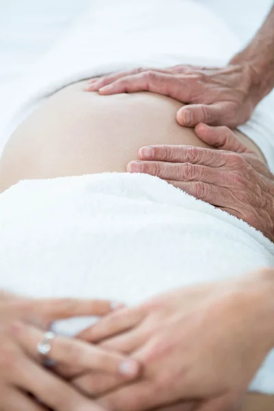 Беременная женщина получает массаж желудка — стоковое фото