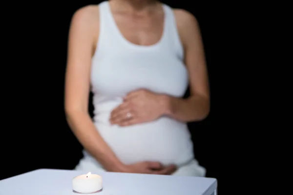 Zwangere vrouw en glas op tafel — Stockfoto