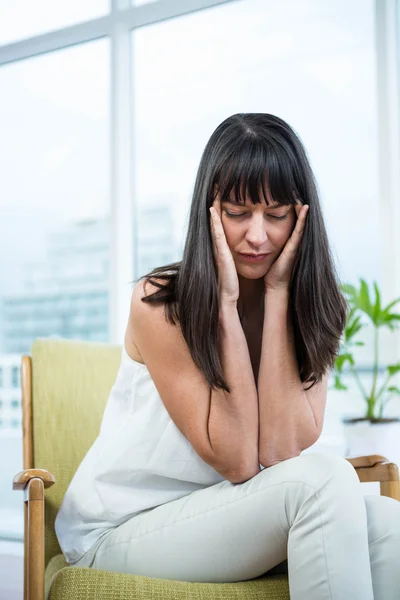 Mujer embarazada sentada con dolor de cabeza — Foto de Stock