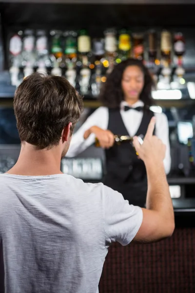 Мужчина заказывает выпивку в баре — стоковое фото