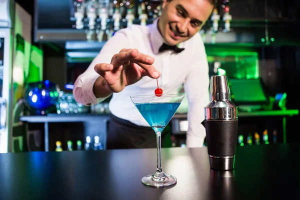 Bartender garnishing cocktail with cherry — Stock Photo, Image