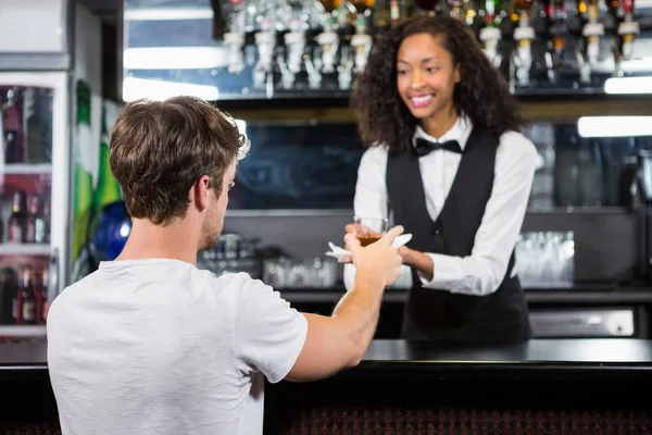 Barmaid servindo bebida para o homem — Fotografia de Stock