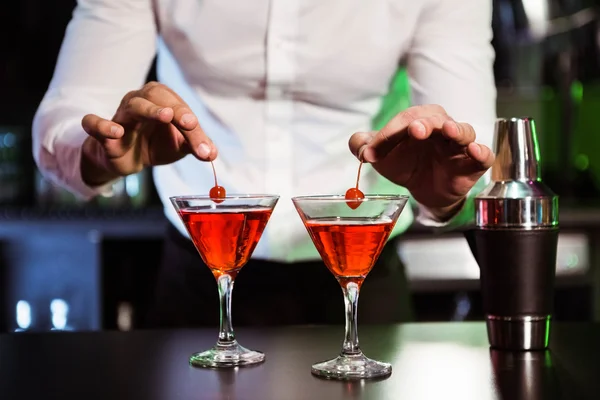 Bartender garnishing cocktail with cherry — Stock Photo, Image