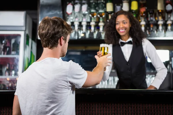 Barmaid serving beer to man — Stock Photo, Image