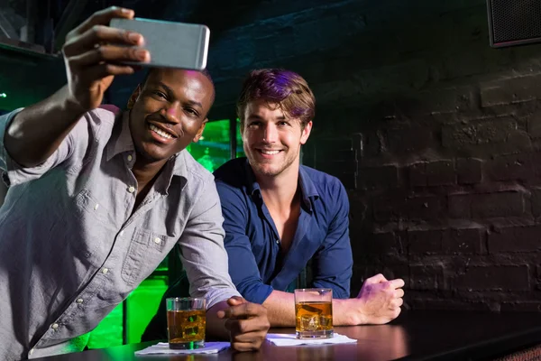 Dos hombres tomando una selfie por teléfono en el mostrador del bar —  Fotos de Stock