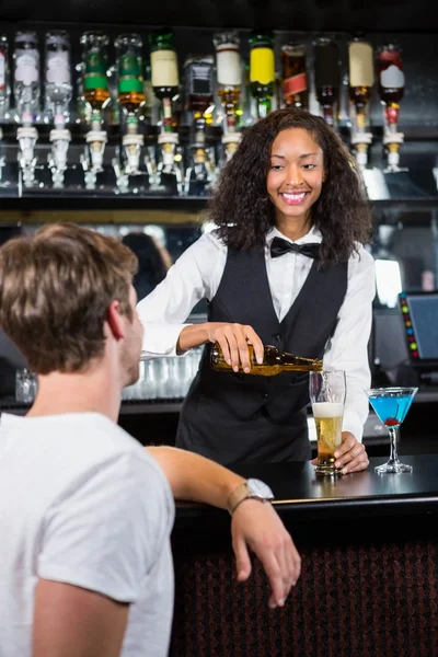 Hermosa camarera vertiendo cerveza en vidrio — Foto de Stock