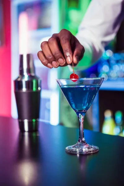 Bartender garnishing cocktail with cherry — Stock Photo, Image