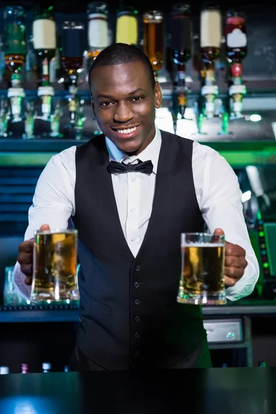 Barman servindo dois copos de cerveja — Fotografia de Stock