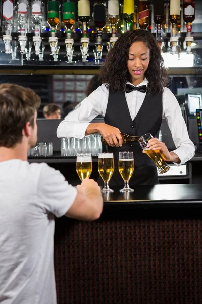 Beautiful barmaid serving beer — Stock Photo, Image