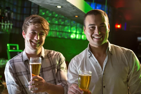 Портрет двух мужчин, пьющих пиво в баре — стоковое фото